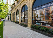 Thumbnail 19 of 28 - A sidewalk in front of a building with a large window advertising the Van Barton Group.