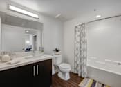 Thumbnail 26 of 28 - A white bathroom with a toilet, sink, and bathtub.