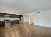 Thumbnail 24 of 28 - A kitchen with dark wood floors and white walls.