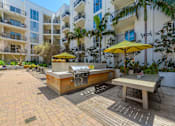 Thumbnail 22 of 28 - A patio with a table and chairs and a grill.