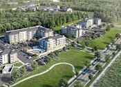 Thumbnail 2 of 18 - A large building complex with a parking lot in front.