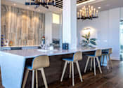 Thumbnail 9 of 18 - A modern kitchen with a bar area and a dining table.
