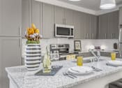 Thumbnail 16 of 18 - A kitchen with a countertop and a microwave above it.