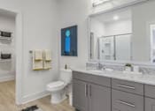 Thumbnail 18 of 18 - A bathroom with a toilet, sink, and a mirror.