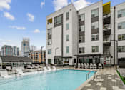 Thumbnail 7 of 25 - a swimming pool in front of a building at Link Apartments® Mint Street, Charlotte