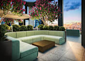 Thumbnail 18 of 34 - A modern outdoor seating area with a curved sofa and a wooden coffee table.