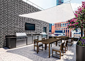Thumbnail 13 of 34 - A patio with a table and chairs and a TV on the wall.