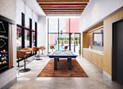 Thumbnail 30 of 34 - A modern living room with a pool table and a bar area.