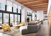 Thumbnail 28 of 34 - A modern living room with a long couch and a coffee table.