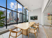 Thumbnail 23 of 39 - A conference room with a long table and chairs with a view of the city outside the window at Link Apartments® QPN, Long Island City, New York