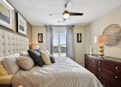 Thumbnail 11 of 28 - a bedroom with a large bed and a ceiling fan at Link Apartments® Brookstown, North Carolina