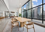 Thumbnail 27 of 39 - A conference room with a long table and chairs with a view of the city outside the windows at Link Apartments® QPN, Long Island City, New York