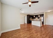 Thumbnail 18 of 28 - an empty living room and kitchen with a ceiling fan at Link Apartments® Brookstown, Winston Salem, NC