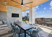 Thumbnail 19 of 32 - a patio with a table and chairs and a tv at Link Apartments® 4th Street, Winston-Salem, North Carolina
