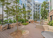 Thumbnail 4 of 22 - Courtyard with seating areas and trees at Link ® Lake Park Apartments, Smyrna, GA