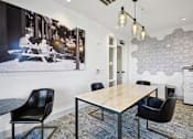 Thumbnail 8 of 32 - a conference room with a table and chairs and a poster on the wall at Link Apartments® 4th Street, North Carolina, 27101