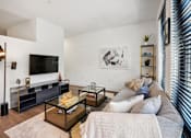 Thumbnail 9 of 32 - a living room with a couch and a television at Link Apartments® 4th Street, Winston-Salem, NC