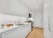 Thumbnail 10 of 39 - A kitchen with white cabinets and a wooden floor.at Link Apartments® QPN, Long Island City, 11101