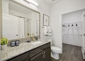 Thumbnail 6 of 32 - a bathroom with a mirror and a toilet and a shower at Link Apartments® 4th Street, Winston-Salem