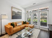 Thumbnail 2 of 32 - a living room with a couch and a glass coffee table at Link Apartments® 4th Street, Winston-Salem, NC
