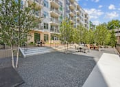Thumbnail 2 of 22 - Outdoor courtyard with gravel seating area at Link ® Lake Park Apartments, Smyrna