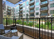 Thumbnail 3 of 32 - a balcony with a view of an apartment building and a pool at Link Apartments® 4th Street, Winston-Salem, NC, 27101