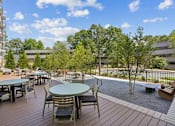Thumbnail 1 of 22 - Outdoor patio with dining tables and playground at Link ® Lake Park Apartments, Georgia