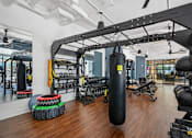 Thumbnail 22 of 32 - a gym with weights and cardio equipment on the walls and a wood floor at Link Apartments® 4th Street, Winston-Salem, 27101