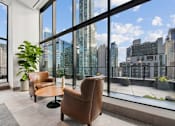 Thumbnail 31 of 39 - A room with a view of the cityscape through large windows at Link Apartments® QPN, Long Island City, New York