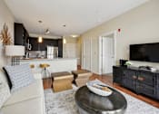 Thumbnail 10 of 28 - a living room and kitchen with a couch and a tv at Link Apartments® Brookstown, Winston Salem, North Carolina