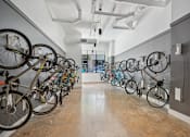 Thumbnail 20 of 32 - a row of bikes hanging on a wall in a room at Link Apartments® 4th Street, Winston-Salem, NC, 27101