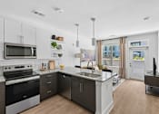 Thumbnail 7 of 22 - Contemporary kitchen with island and pendant lights at Link ® Lake Park Apartments, Smyrna, GA
