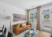 Thumbnail 8 of 22 - Living room with tan leather sofa and glass coffee table at Link ® Lake Park Apartments, Smyrna, 30080