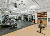 Thumbnail 28 of 32 - a gym with weights and other exercise equipment on a wooden floor  at Link Apartments® H Street, Washington, Washington