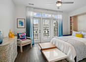 Thumbnail 11 of 25 - a bedroom with a bed and a sliding glass door at Link Apartments® Mint Street, Charlotte, North Carolina