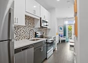 Thumbnail 10 of 25 - Studio kitchen with stainless steel appliances and quartz counters at Link Apartments® Mint Street in Uptown Charlotte, NC. at Link Apartments® Mint Street, Charlotte, NC, 28203
