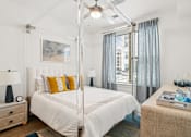 Thumbnail 15 of 25 - a bedroom with a white bed and a large window at Link Apartments® Mint Street, North Carolina, 28203