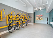 Thumbnail 25 of 25 - a room with several bikes hanging on a wall and a bathroom with sinks at Link Apartments® Mint Street, North Carolina, 28203