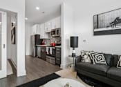 Thumbnail 17 of 25 - a living room with a couch and a table at Link Apartments® Mint Street, North Carolina