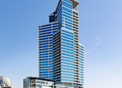 Thumbnail 3 of 33 - A tall blue building stands in front of a white dome and other buildings.