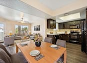 Thumbnail 4 of 33 - A modern kitchen with dark brown cabinets and a wooden dining table set for two.