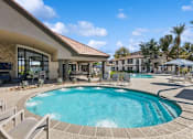 Thumbnail 11 of 20 - a pool with chairs and umbrellas in front of a building