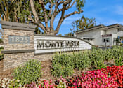 Thumbnail 16 of 17 - The sign for Monte Vista Apartments is surrounded by flowers and greenery.