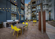 Thumbnail 12 of 25 - an outdoor patio with tables and chairs and string lights
