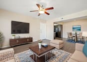 Thumbnail 8 of 33 - A living room with a brown coffee table and a ceiling fan.