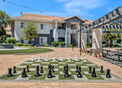 Thumbnail 20 of 27 - A chess board with black and white pieces in front of a building.