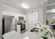 Thumbnail 1 of 20 - A kitchen with a stainless steel refrigerator, microwave, oven, and sink.
