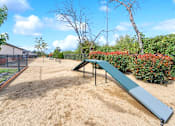 Thumbnail 32 of 37 - a blue park bench in a fenced in area with bushes and trees