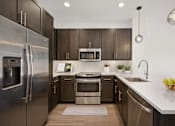 Thumbnail 2 of 24 - a kitchen with stainless steel appliances and wooden cabinets