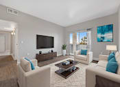 Thumbnail 3 of 27 - A living room with a large couch, a coffee table, and a television.